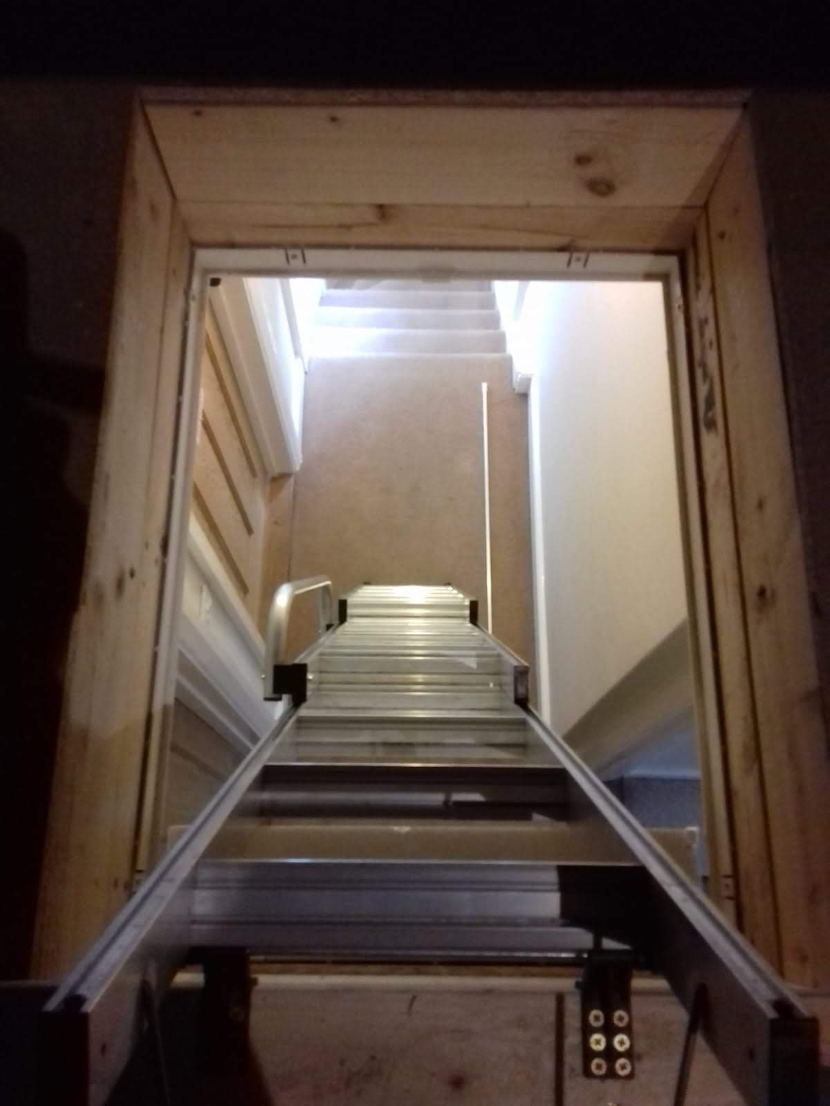 Loft installer measuring loft hatch for enlargement